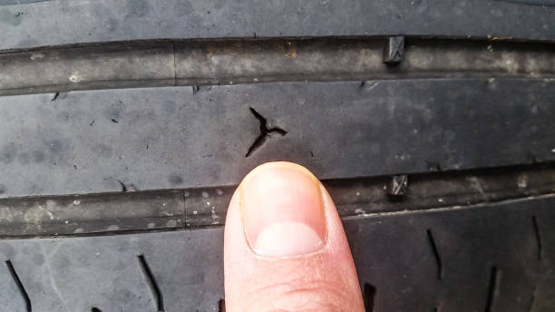 Human finger pointing at tyre puncture, at close-up stock photo