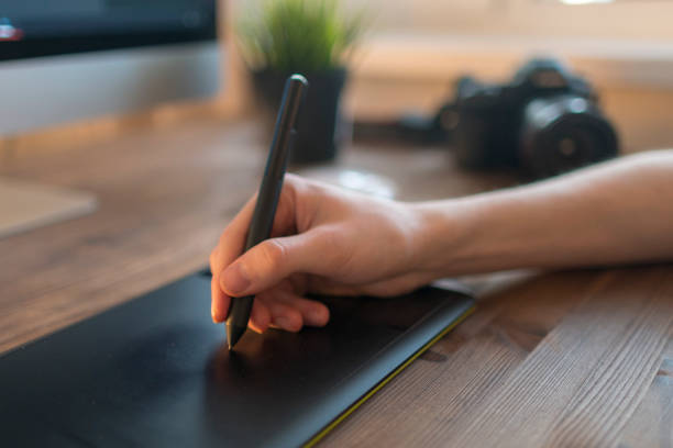 istock Man hand drawing with a display pen and a laptop 943620308