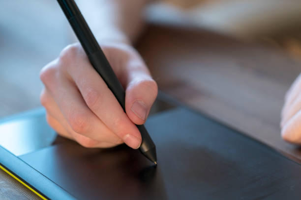 istock Man Drawing with a Digital Pen and Tablet 943620314