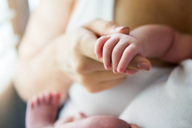 istock Newborn Baby Hands with Mother 943621086