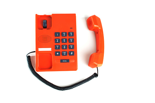 Orange colored telephone on white background