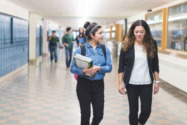 istock Ethnic teacher walks with one of her students down the hallway 943624526