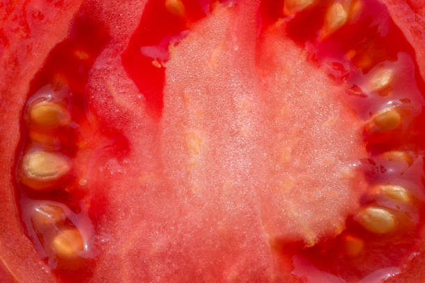 istock Tomato cut in half on the table macro photo. 943624640