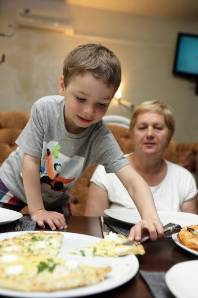 istock Grandmother and grandson eating pizza 943638520