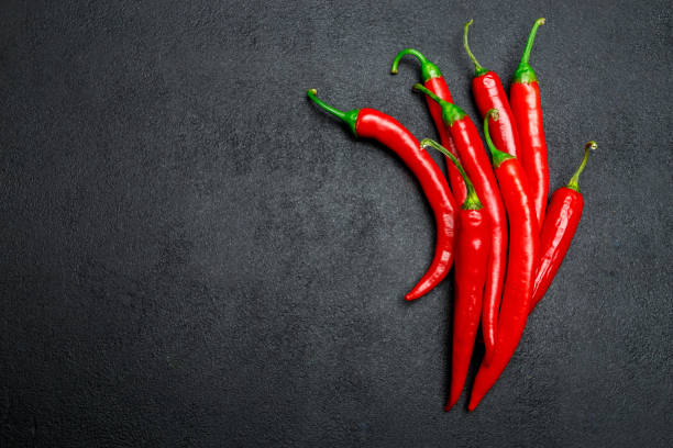 istock red chili pepper on dark concrete background 943639466