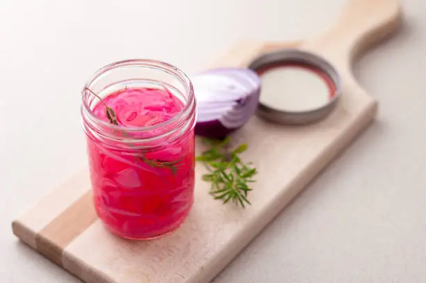 Pickled onions in a glass jar. Pickling red onions is easy, simply marinate the onions in a brine with vinegar, salt and herbs. Pickled food can be preserved in glass jar for a very long time!