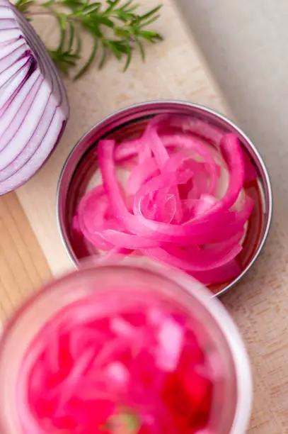 Red onions pickled from above. Pickling red onions is easy, simply marinate the onions in a brine with vinegar, salt and herbs. Pickled food can be preserved in glass jar for a very long time!
