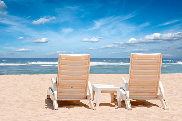 istock Two sun beach chairs on coast near ocean 94364624