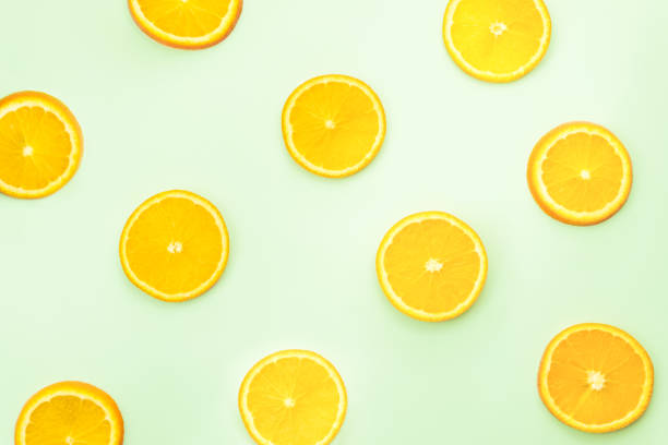 istock Sliced oranges on green background, top view 943648522