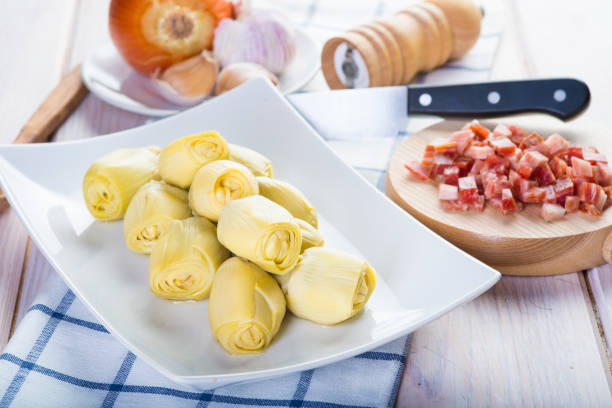 Ingredients for cooking sauteed baby artichoke hearts with ham