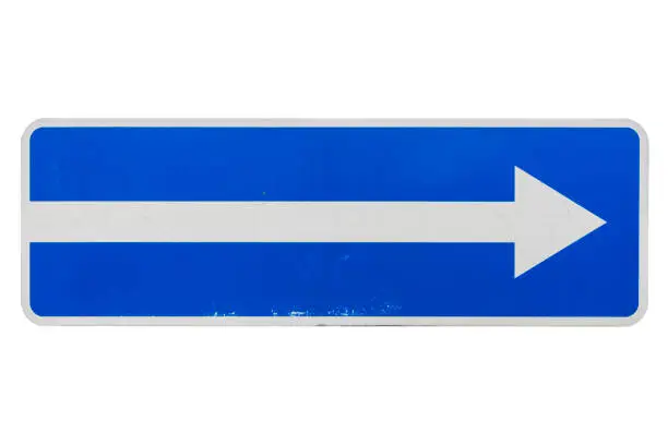 Photo of One way street in direction of arrow road sign isolated on white.