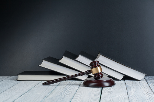 Concepto de derecho - libro de la ley abierta con un mazo de madera de jueces de mesa en una oficina de aplicación de la ley o Tribunal aislada sobre fondo blanco. Copiar espacio para texto photo