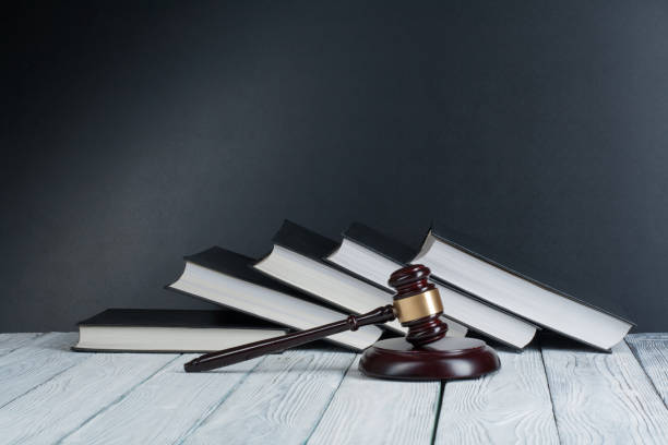 법 개념-흰색 배경에 고립 된 법정 또는 법 집행 사무실에서 테이블에 나무 판사 망치와 오픈 법률 책. 텍스트를 위한 공간 복사 - 눈금자 뉴스 사진 이미지