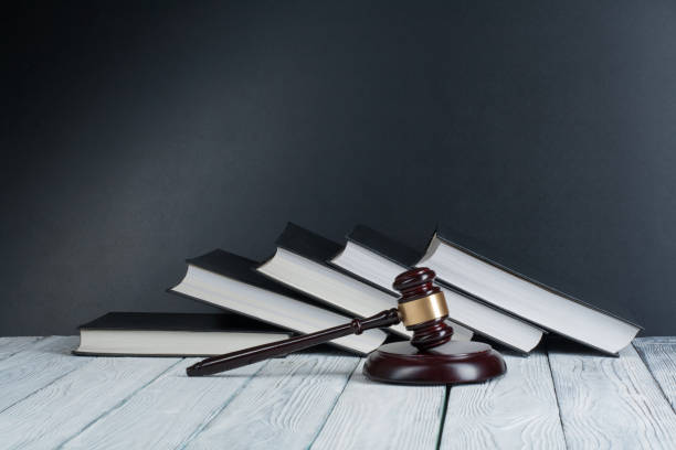 law concept - open law book with a wooden judges gavel on table in a courtroom or law enforcement office isolated on white background. copy space for text - praticar imagens e fotografias de stock