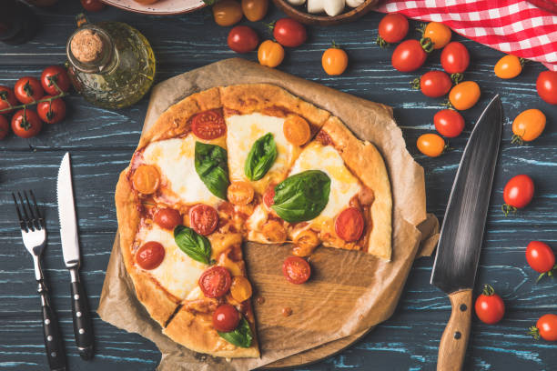 istock top view of appetizing tasty pizza and cherry tomatoes on table 943665598