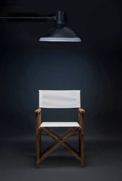 istock Folding director's chair in a photo studio on a blue background. 943668594
