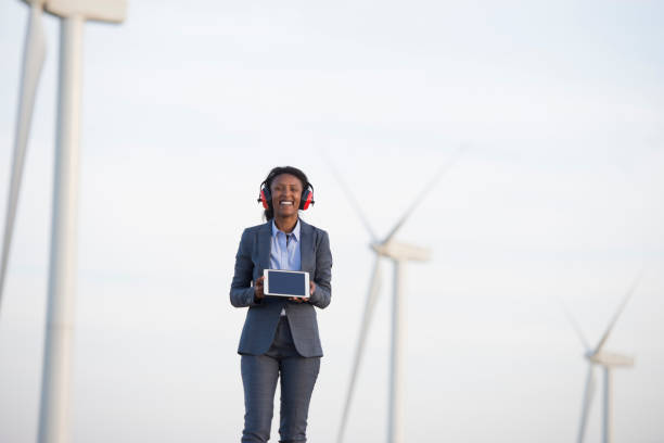istock Sustainable energy engineer showing a tablet computer at a wind farm. 943671214