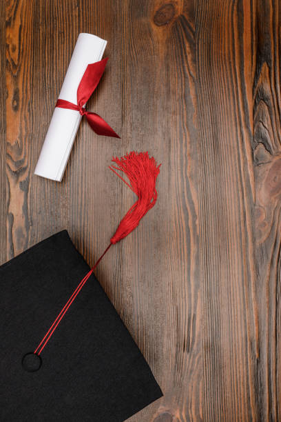 istock Top view of diploma and square academic hat on wood background 943674942