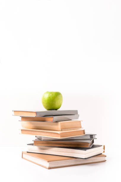 istock Apple on pile of books isolated on white 943675524