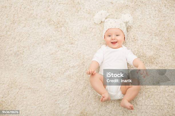 Happy Baby In Hat And Diaper On Carpet Background Smiling Infant Kid Boy In White Clothing Stock Photo - Download Image Now