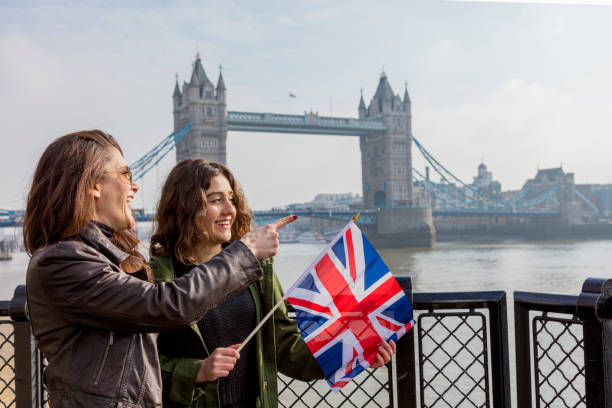istock Tourist friends holding British flag 943681826