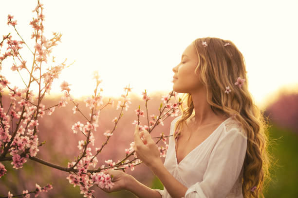 istock Beautiful young woman with cherry blossom at spring 943685018