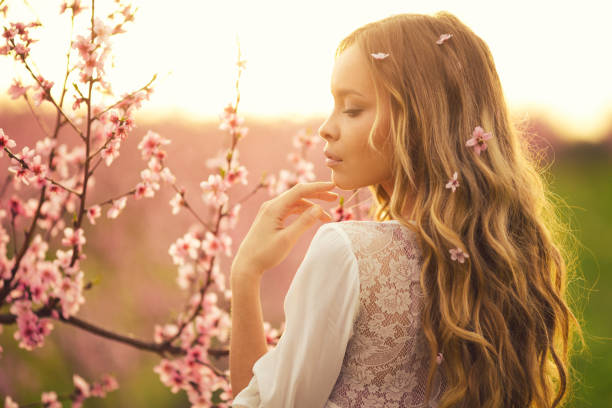 istock Beautiful young woman with cherry blossom at spring 943685128