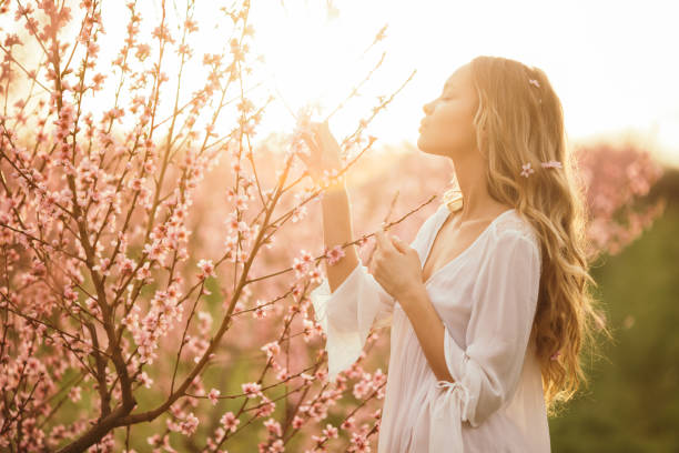 istock Beautiful young woman with cherry blossom at spring 943685174