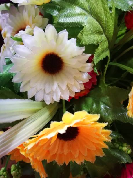 istock multi color of plastic flowers for decorations on office table 943688898