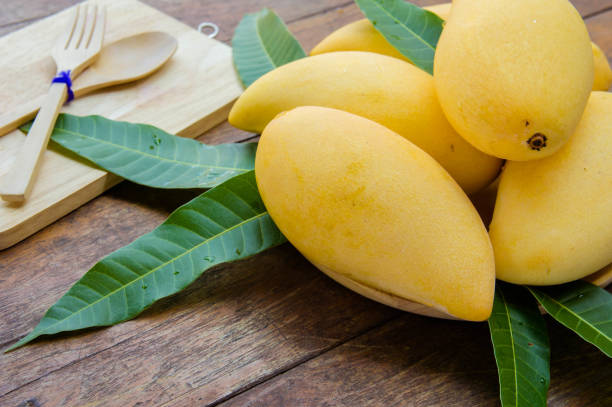 istock sweet yellow mango fruit on summer on wood table 943691386