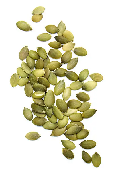Photo of Green pumpkin seeds on white background