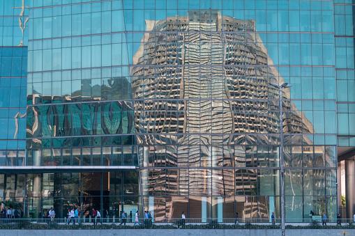 Metropolitan Cathedral of Saint Sebastian in Rio de Janeiro, Brazil, reflected in a modern office building opposite, with incidental people visible