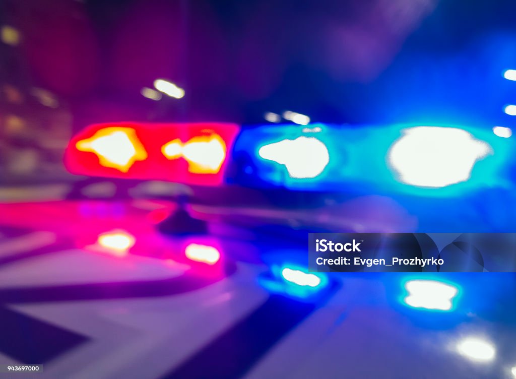 Police car lights in night time, crime scene, night patrolling the city. Abstract blurry image. Police Vehicle Lighting Stock Photo