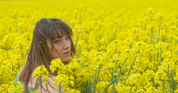 young beautiful women in an oilseed field.