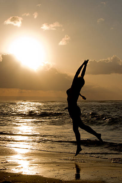 istock Girl jumping on sunrise at the beach 94370387