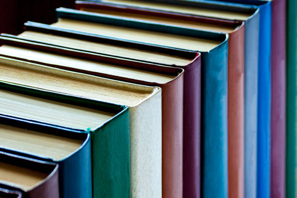 istock Colorful books are arranged in a row on a dark background 943709252