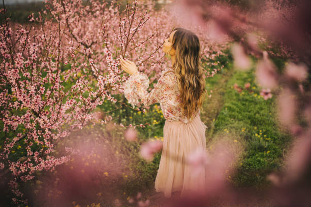 istock Beautiful young woman with cherry blossom at spring 943709918