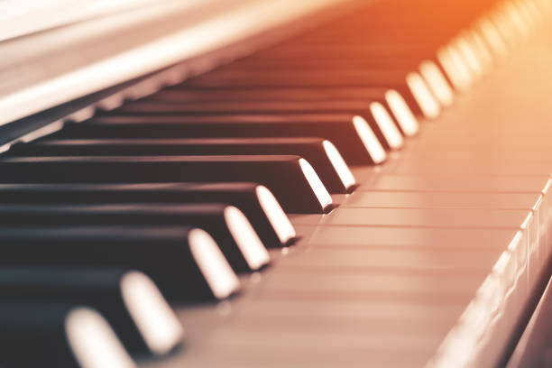 Piano keys illuminated by sunlight, side view close-up with shallow depth of field (toned)