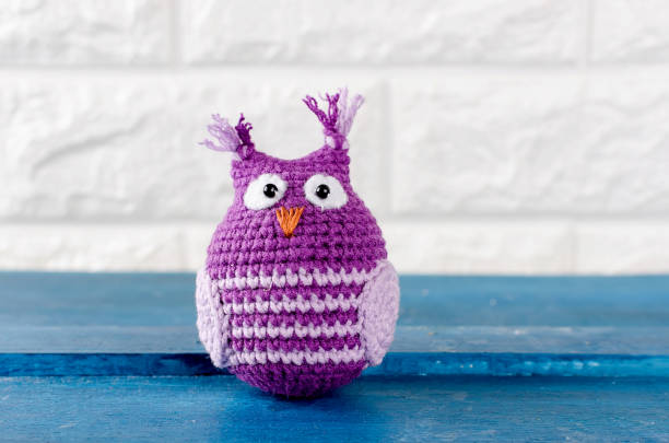 istock Cute handmade purple with pink knitted owl toy 943719034