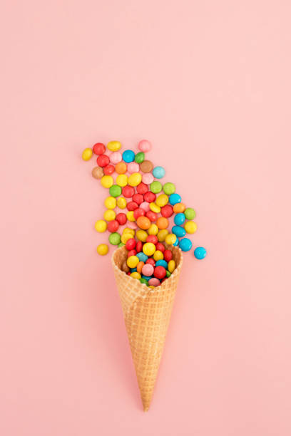 istock Multicolored lollipops in waffle cone on pink background 943721852
