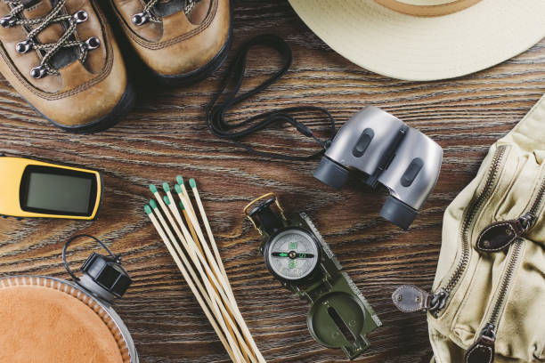istock Hiking or travel equipment with boots, compass, binoculars, matches on wooden background. Active lifestyle concept. 943728038