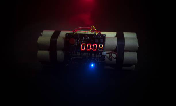 Image of a time bomb against dark background. Timer counting down to detonation illuminated in a shaft light shining through the darkness, conceptual image