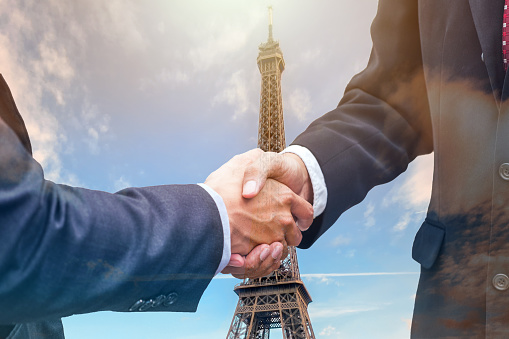 Handshake agreement of businessman with partnership on eiffel tower background