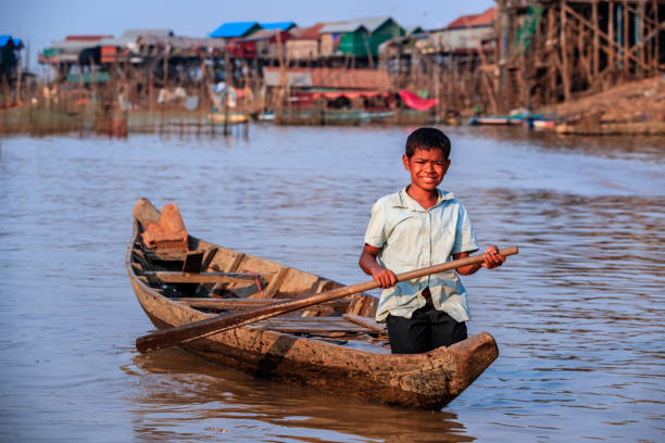 istock Cambodian young boy rowing a boat, Tonle Sap, Cambodia 943733156
