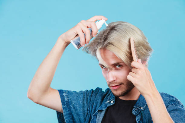 istock Man applying spray cosmetic to his hair 943733298