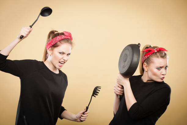 istock Kitchen fight between retro girls. 943735706