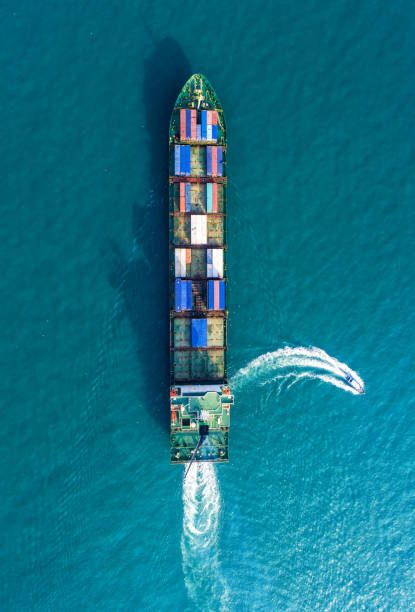 istock Container ship in export and import business and logistics. Shipping cargo to harbor by crane. Water transport International. Aerial view 943744074