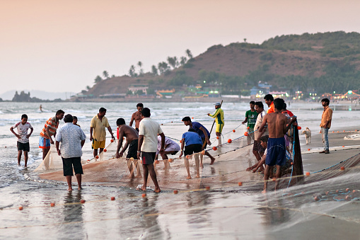 GOA, INDIA - NOVEMBER 18: Fishermans picking up their nets on November 18, 2011, Goa, India.