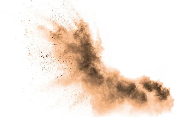 Photo of Abstract  brown colored sand splash on white background. Color dust explode on background  by throwing freeze stop motion.