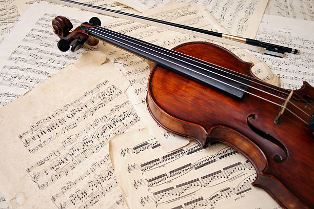 Violin with bow on sheet music Violin with bow and music sheet orchestra photos stock pictures, royalty-free photos & images
